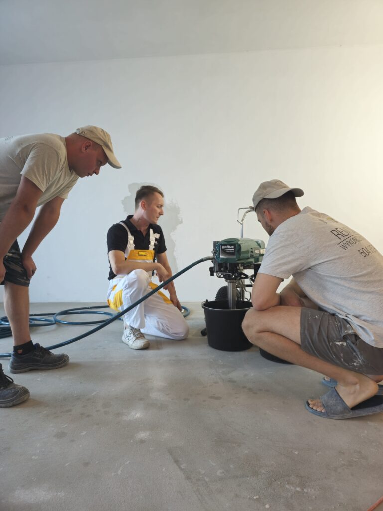 Praktyczna nauka obsługi agregatu Gröne PowerSpray 81 podczas natrysku gładzi na ścianie