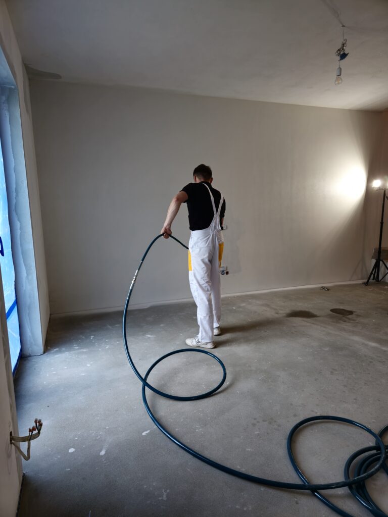 Pokaz prawidłowej techniki natrysku gładzi agregatem Gröne PowerSpray 81 w warunkach budowy